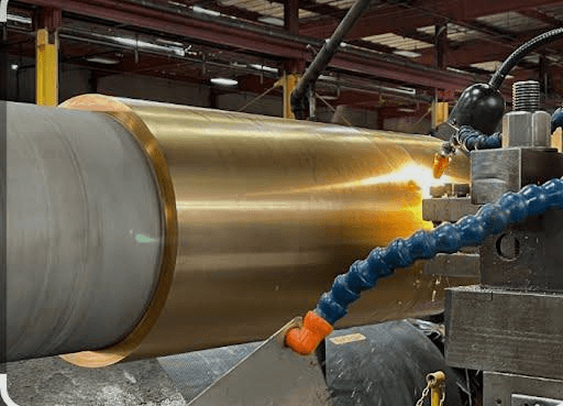 Bronze sleeve being welded onto a roll in the shop